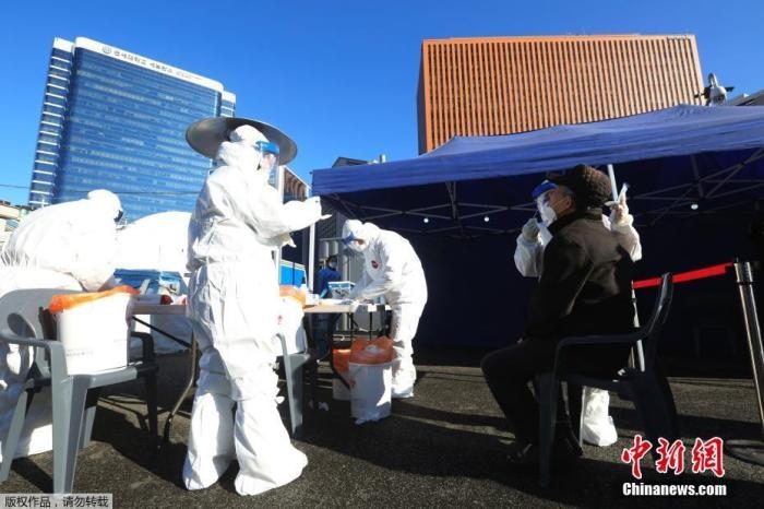 資料圖：韓國(guó)首爾，醫(yī)務(wù)人員對(duì)市民進(jìn)行新冠病毒檢測(cè)。