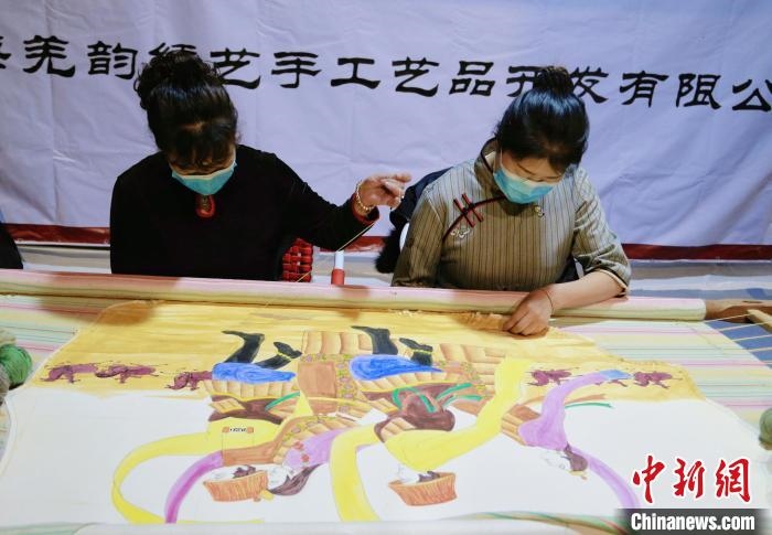 圖為皮繡藝人在市集上“秀”指尖技藝。　馬銘言 攝