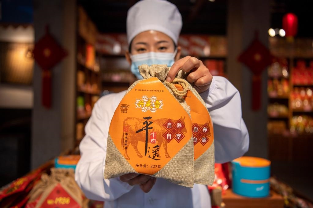1月27日，在平遙古城南大街的一家平遙牛肉店內，工作人員展示一款牛肉產(chǎn)品。新華社記者 楊晨光 攝