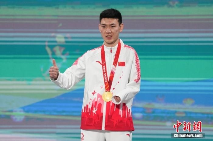 3月6日，梁景怡在延慶頒獎廣場領獎臺上豎起大拇指。當日，在國家高山滑雪中心舉行的北京2022年冬殘奧會殘奧高山滑雪男子超級大回轉(zhuǎn)—站姿決賽中，中國選手梁景怡奪得冠軍。 <a target='_blank' href='/'>中新社</a>記者 楊華峰 攝