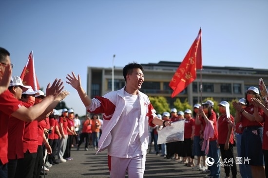 6月7日，在北京市人大附中通州校區(qū)考點，考生與送考老師擊掌加油。人民網(wǎng)記者 翁奇羽攝