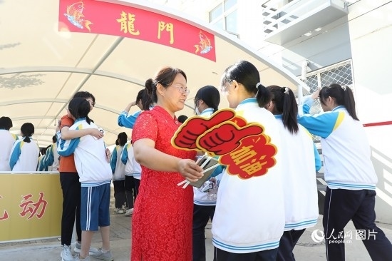 6月7日一早，雄安新區(qū)安新中學老師在給同學們加油鼓勁兒。人民網(wǎng) 李兆民攝