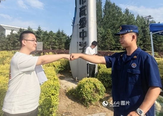 6月7日，遼寧營口老邊區(qū)消防救援大隊的消防員為高考學子加油助威。人民網(wǎng)記者 尹柏寒攝