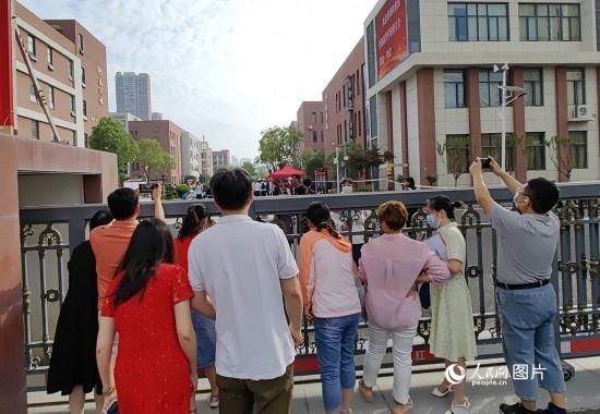 6月7日，武漢市第三中學考點，考生進場后，家長在柵欄外用手機拍攝自己的孩子。人民網(wǎng)記者 郭婷婷攝