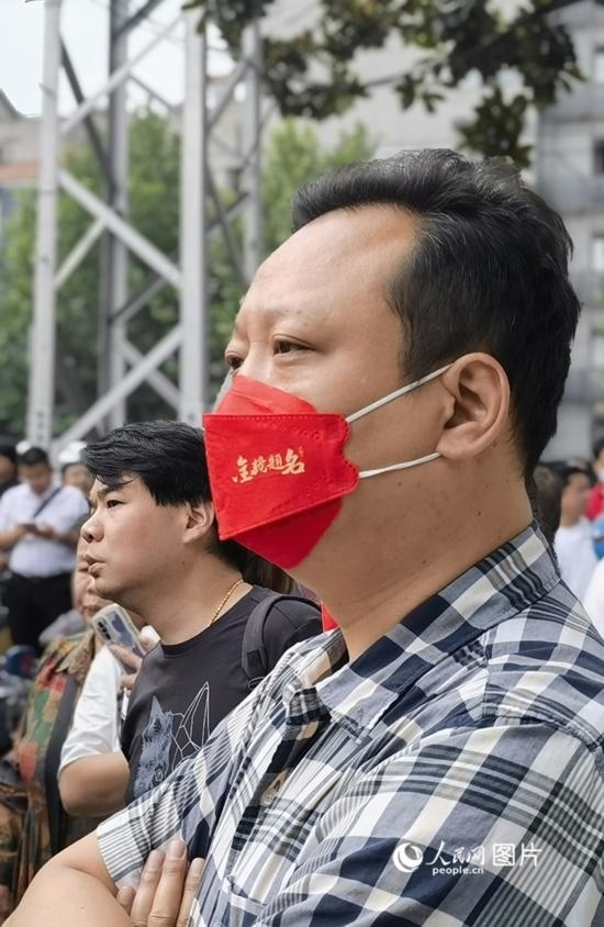 6月7日早，在武漢市第二十六中學考點外，送考家長戴著印有“金榜題名”的口罩。人民網(wǎng) 周雯攝
