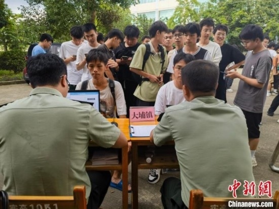 專武干部在發(fā)放兵役登記證。韋碩 攝