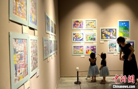 圖為家長帶著孩子參觀展覽。呂明 攝