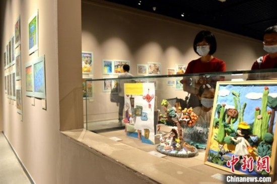 圖為家長帶著孩子參觀展覽。呂明 攝