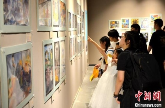 圖為家長帶著孩子參觀展覽。呂明 攝