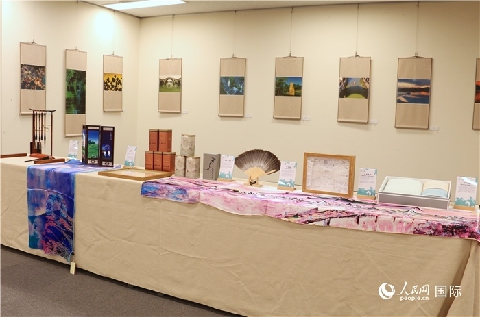 現場展出的馮學敏攝影作品與湖州市特色工藝品。（人民網 許可攝）