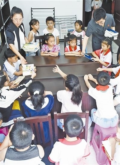  圖④：法院干警為留守兒童發(fā)放暑假讀物。