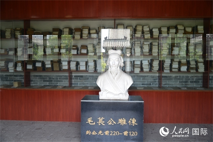 河間詩(shī)經(jīng)齋毛萇雕像。雕像后書(shū)櫥中陳列的是歷代各版本《詩(shī)經(jīng)》及譯本。 人民網(wǎng) 趙昭攝