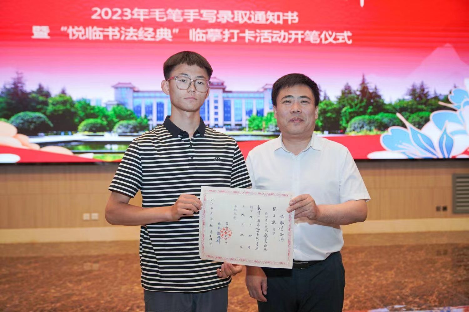 陜西師范大學(xué)黨委書記李忠軍為2023級新生代表張占彪同學(xué)發(fā)放錄取通知書。校方供圖