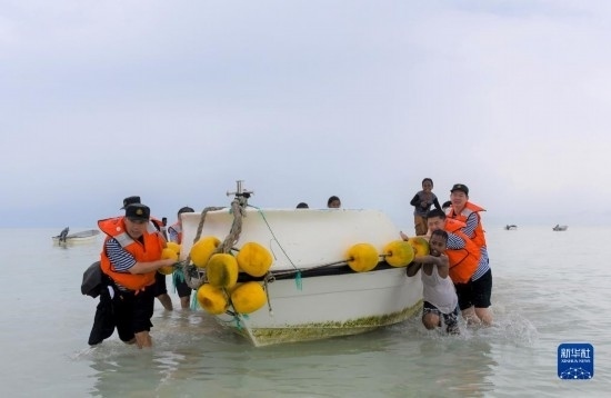 7月21日，中國海軍“和平方舟”號(hào)醫(yī)院船醫(yī)護(hù)人員涉水登島，前往基里巴斯一診療點(diǎn)。新華社記者 黎云 攝