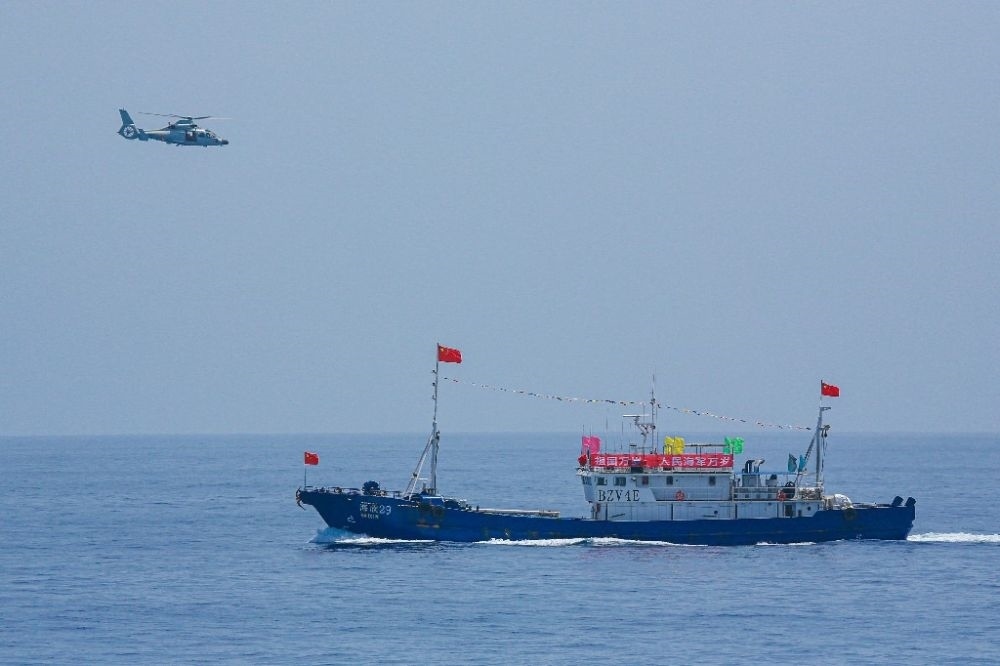 ↑中國海軍第40批護航編隊中的艦載直升機在被護船只周邊海域巡邏警戒（2022年6月4日攝）。新華社發(fā)（唐文 攝）