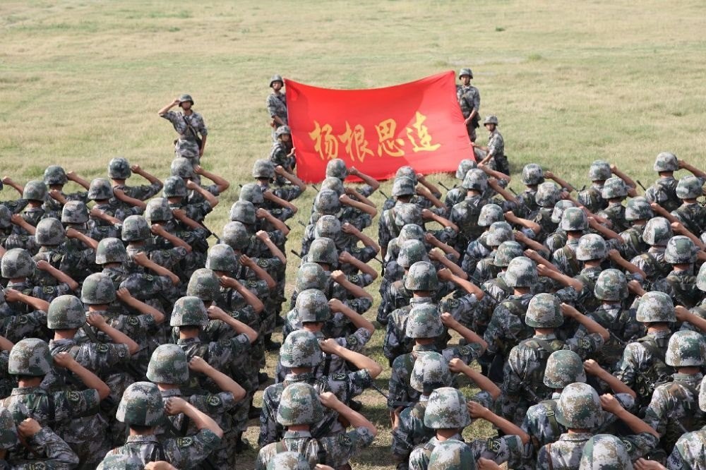 ↑“楊根思連”官兵執(zhí)行任務(wù)前向連旗宣誓（資料照片）。新華社發(fā)