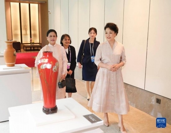 7月27日下午，國(guó)家主席習(xí)近平夫人彭麗媛在四川成都會(huì)見(jiàn)陪同印度尼西亞總統(tǒng)佐科來(lái)華出席第31屆世界大學(xué)生夏季運(yùn)動(dòng)會(huì)開(kāi)幕式并訪華的總統(tǒng)夫人伊莉亞娜。這是彭麗媛和伊莉亞娜欣賞成都特色非遺工藝品。新華社記者 丁林 攝