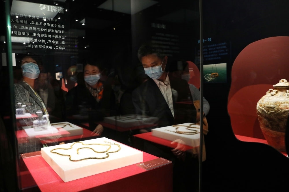 參觀者在上海臨港新城的中國航海博物館航海文物展上的“南海一號”出水的宋代金項飾展柜前駐足觀看（2020年12月28日攝）。新華社記者 方喆 攝