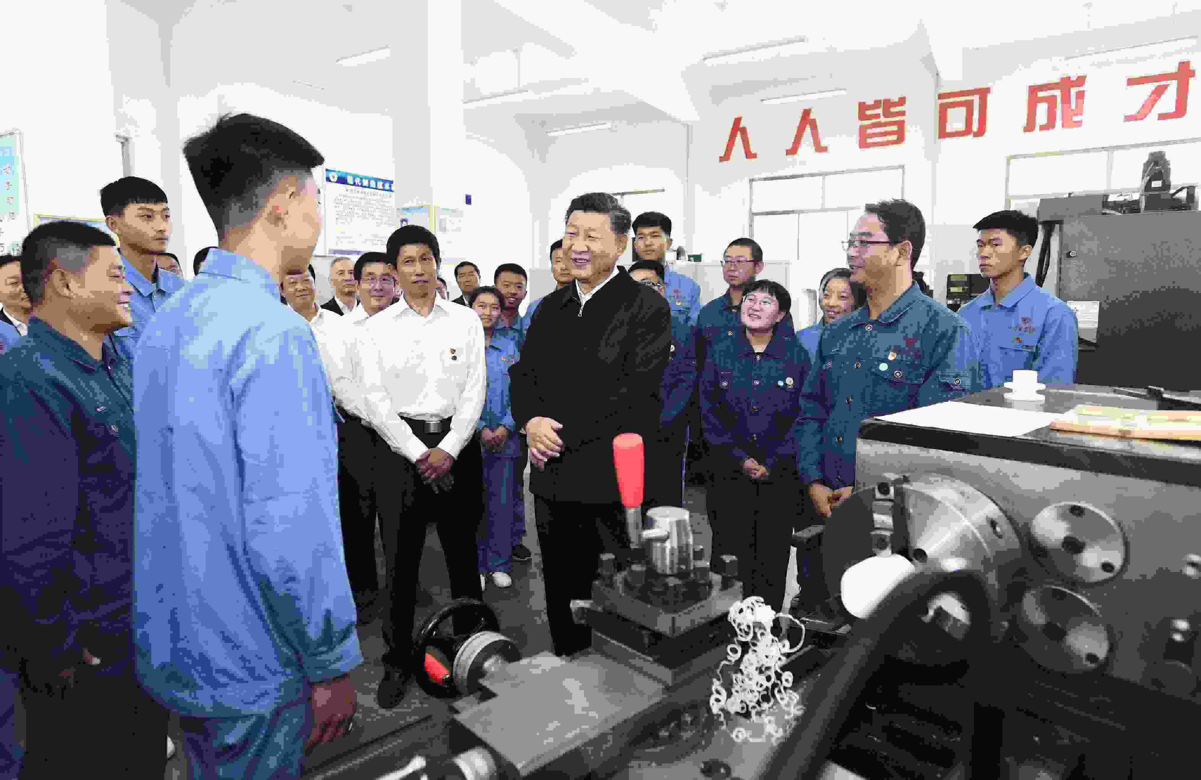 2019年8月20日，習近平在甘肅省張掖市山丹培黎學?，F(xiàn)代制造技術(shù)實訓室，觀看職業(yè)技能實訓，同師生親切交流。