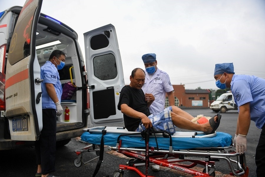 8月1日，在北京市門頭溝區(qū)妙峰山鎮(zhèn)妙峰山民族學(xué)校臨時(shí)安置點(diǎn)，北京急救中心工作人員在轉(zhuǎn)運(yùn)一名受傷村民。新華社記者 鞠煥宗 攝