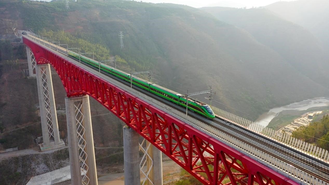 中老鐵路國際旅客列車在云南省境內的元江特大橋上飛馳。姚巍攝