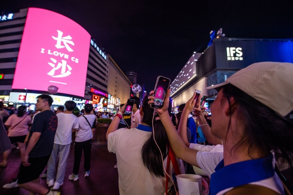  游客在長(zhǎng)沙市天心區(qū)黃興路步行街打卡、拍照（6月7日攝）。新華社記者 陳思汗 攝