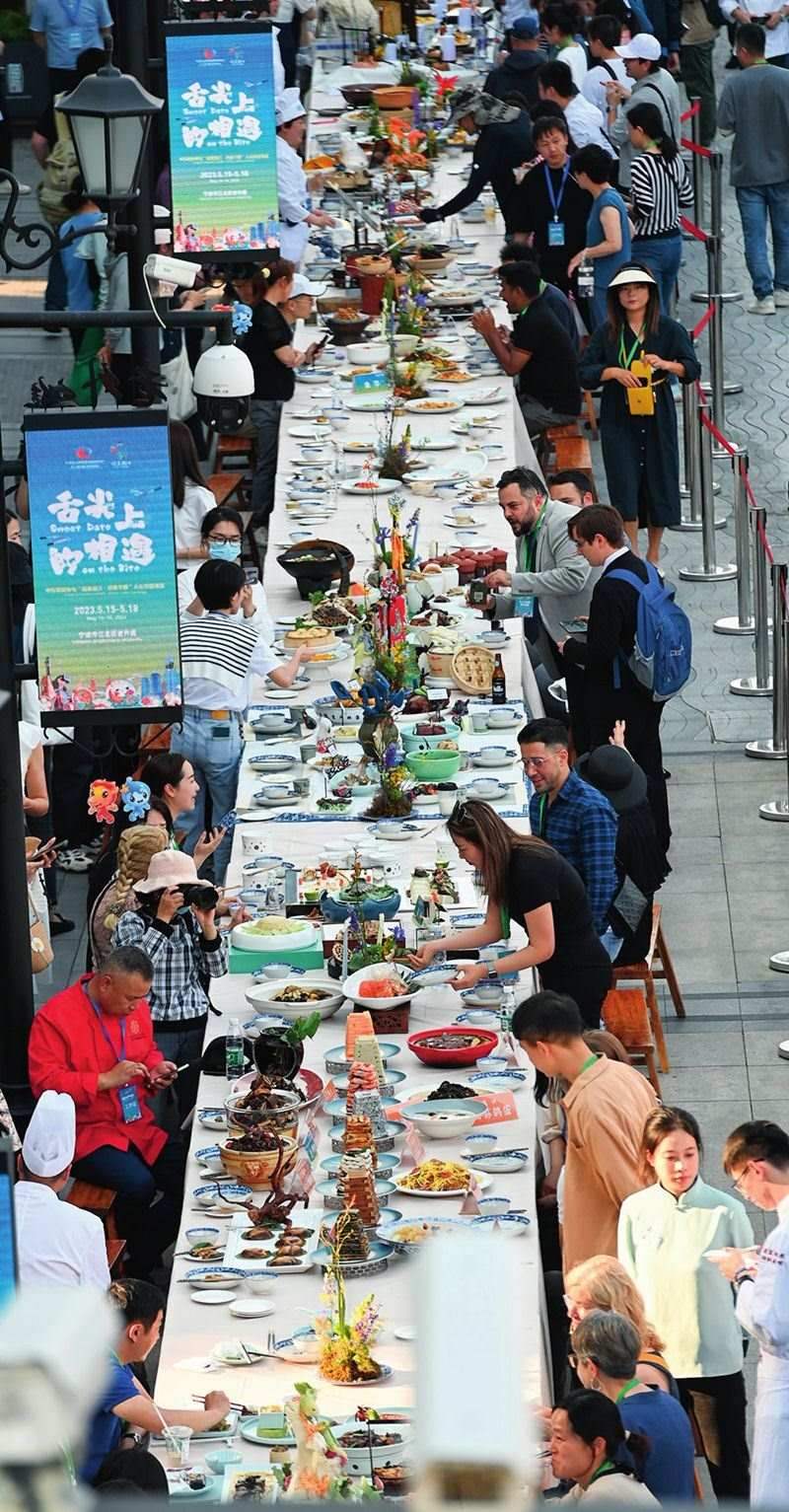 市民和游客在寧波舉辦的第三屆中國—中東歐國家博覽會(huì)暨國際消費(fèi)品博覽會(huì)上品嘗融合中國和中東歐美食的長桌宴（2023年5月15日攝）。黃宗治攝/本刊