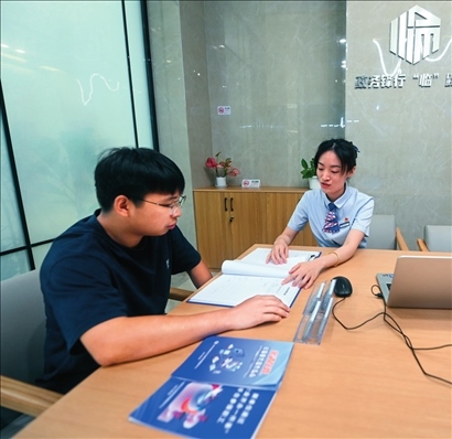 在杭州市臨安區(qū)政務(wù)服務(wù)中心的“為企服務(wù)中心”，黨員志愿者（右）解答企業(yè)主的疑問（2023年7月7日攝）。徐昱攝/本刊