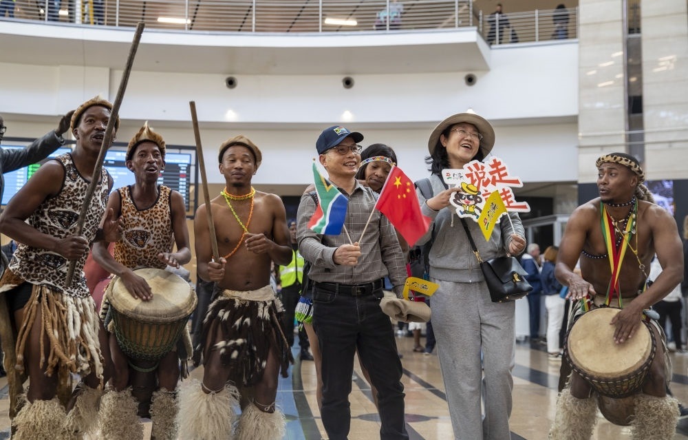 在南非約翰內(nèi)斯堡坦博國際機場，南非舞蹈演員歡迎中國試點恢復(fù)出境團隊旅游后首批抵達南非的中國游客（2023年3月29日攝）。