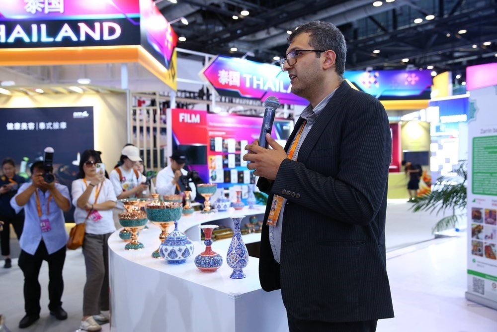 9月1日，參展商在國(guó)家會(huì)議中心向媒體記者介紹展臺(tái)信息。新華社記者 孫瑋彤 攝