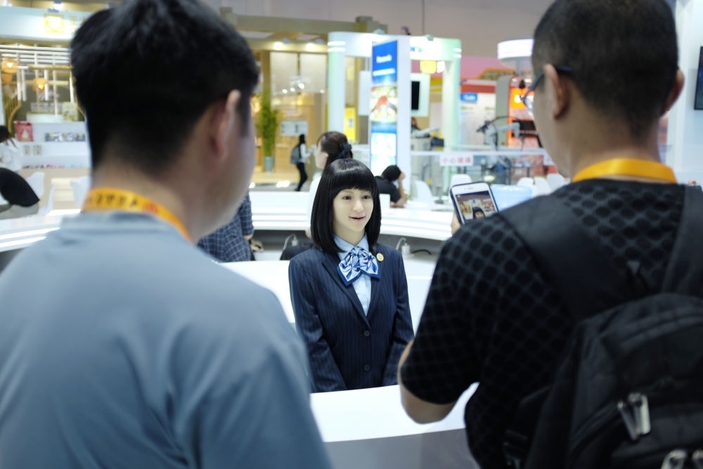 9月1日，媒體記者在國(guó)家會(huì)議中心與服務(wù)機(jī)器人互動(dòng)。新華社記者 劉夢(mèng)琪 攝