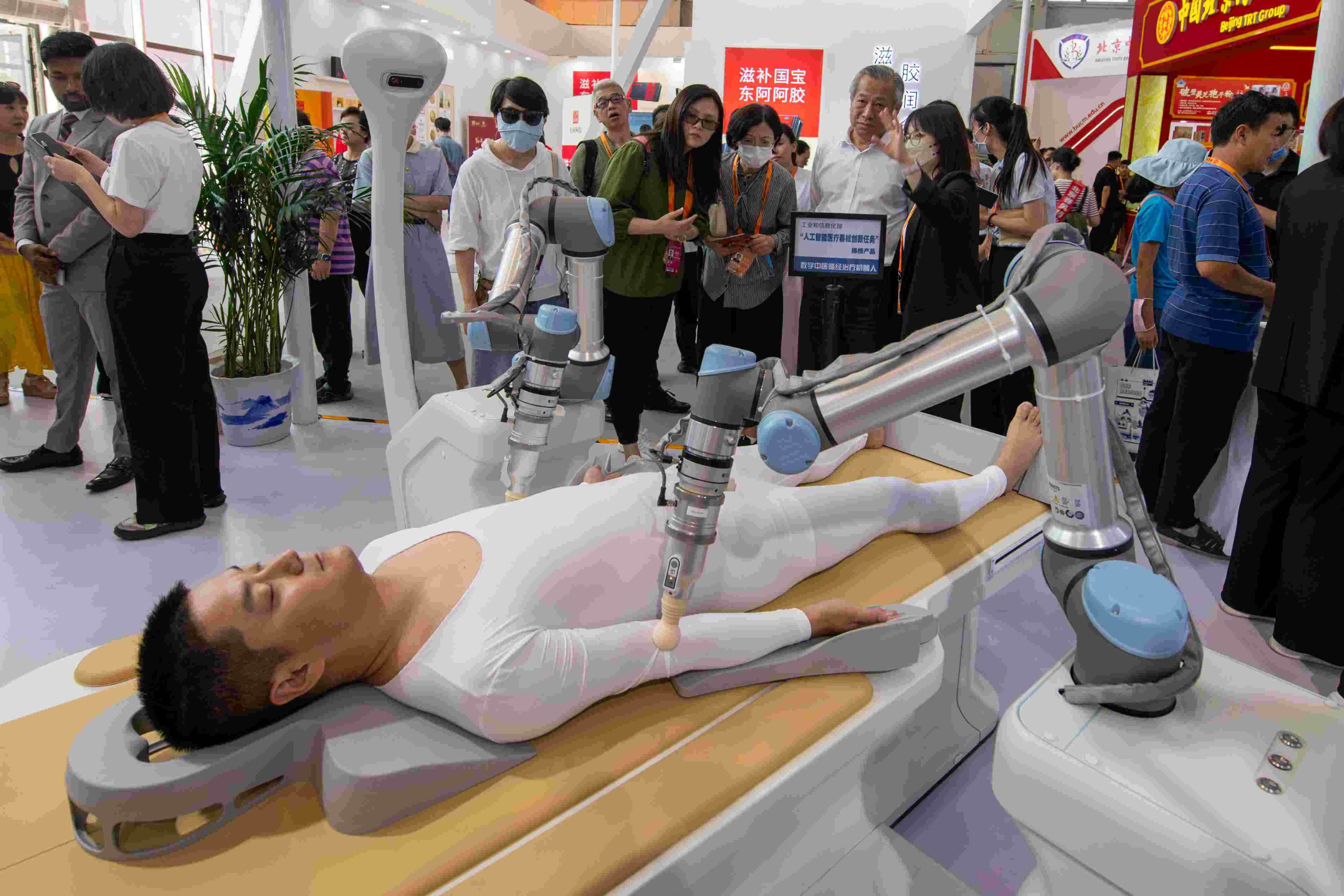 在位于首鋼園的健康衛(wèi)生服務(wù)展區(qū)，觀眾正在參觀數(shù)字中醫(yī)循經(jīng)治療機(jī)器人。人民網(wǎng)記者 翁奇羽攝