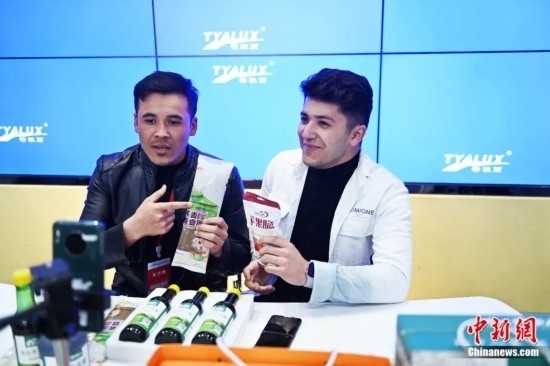 2023年3月，甘肅省慶陽市環(huán)縣電商創(chuàng)業(yè)孵化基地內(nèi)，來自蘭州文理學(xué)院的塔吉克斯坦留學(xué)生正在協(xié)助主播直播帶貨當(dāng)?shù)剞r(nóng)特產(chǎn)品。李亞龍 攝