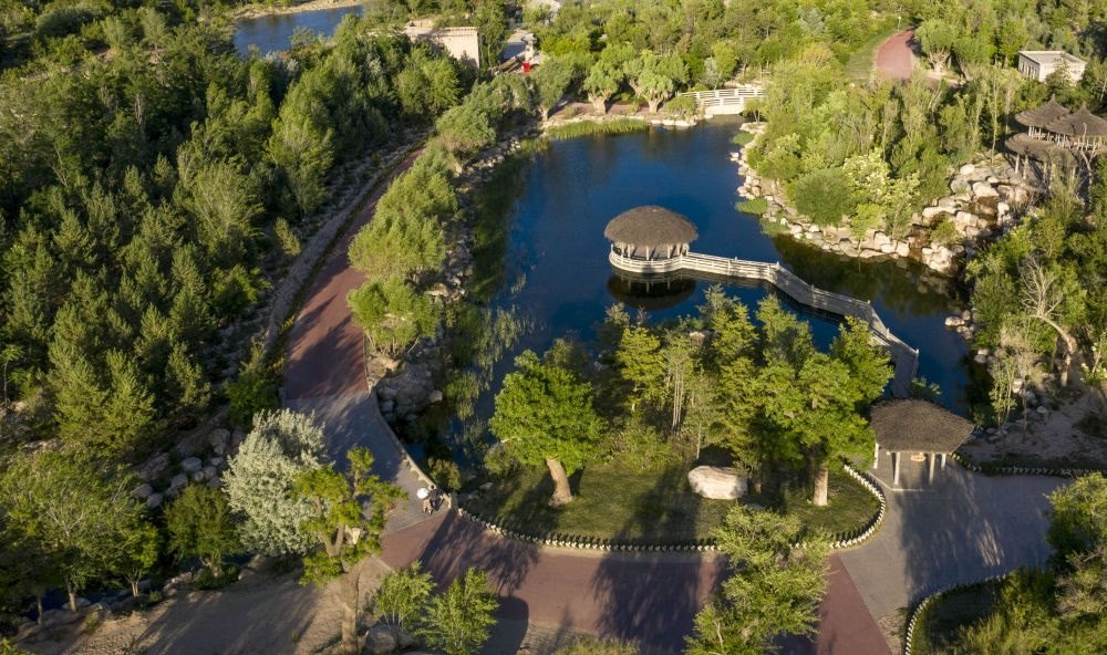 坐落在寧夏銀川市賀蘭山腳下的賀蘭山運(yùn)動(dòng)休閑公園（2021年5月27日攝，無(wú)人機(jī)照片）。這里曾是一片砂石采礦塌陷區(qū)，當(dāng)?shù)赝ㄟ^(guò)植被景觀再造、水系建設(shè)、現(xiàn)代管網(wǎng)鋪建等手段，重新利用廢石、廢坑及各類廢棄建筑材料，把這里變成一座免費(fèi)開(kāi)放的主題公園。新華社記者 馮開(kāi)華 攝