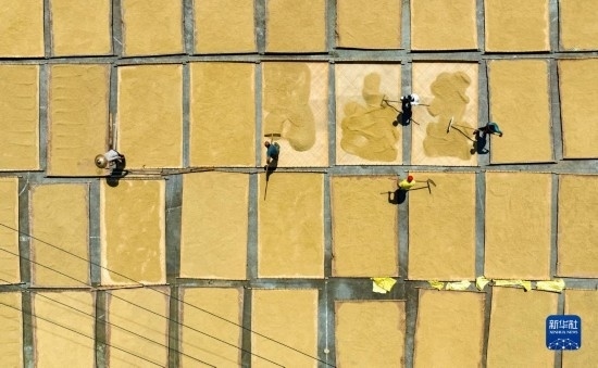 9月16日，在湖南省懷化市通道侗族自治縣萬(wàn)佛山鎮(zhèn)溪上村，村民在晾曬稻谷（無(wú)人機(jī)照片）。