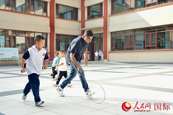 來(lái)自巴基斯坦的沙杰在滾鐵環(huán)。人民網(wǎng) 盧鵬宇攝