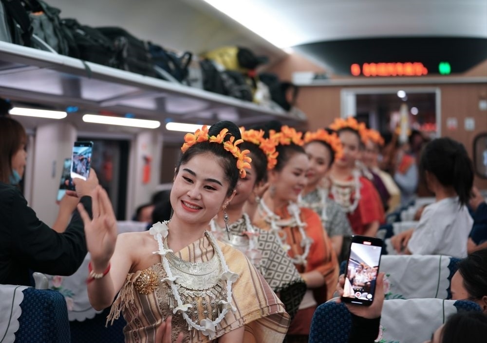 2023年4月13日，老撾工作人員在中老鐵路上開行的D887次國際旅客列車上表演。新華社記者 邢廣利 攝