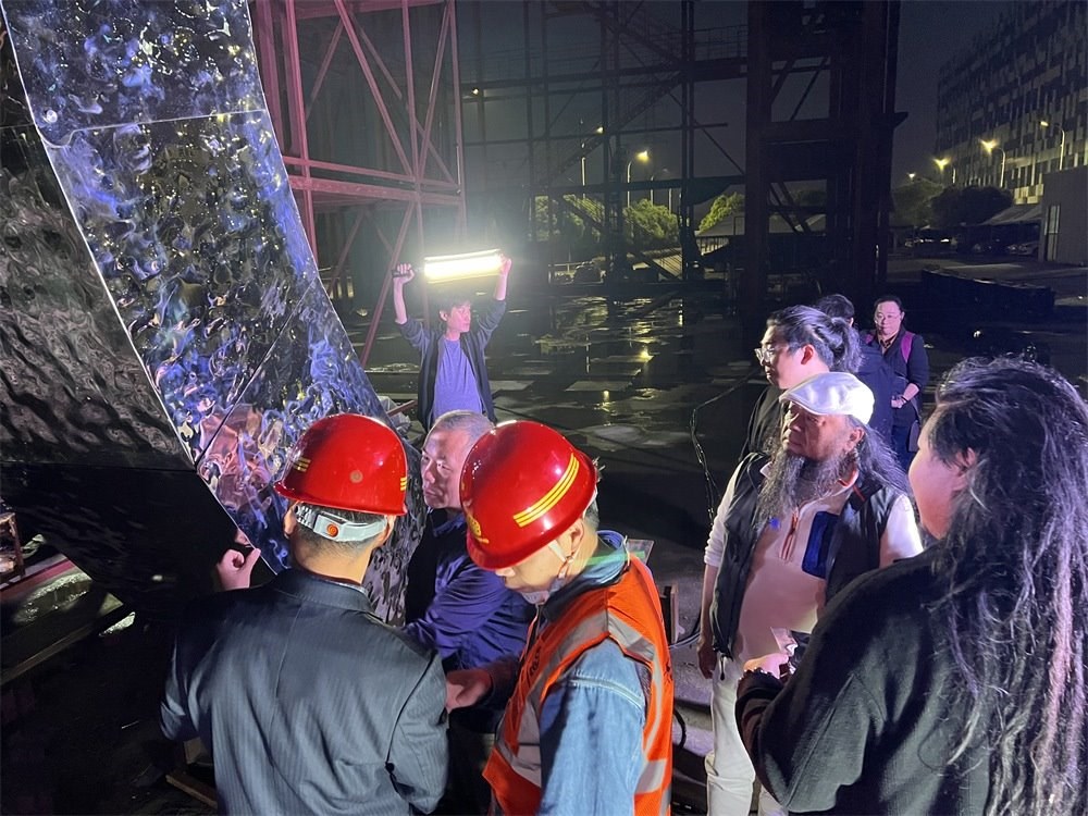 林崗（右二）和團(tuán)隊(duì)查看主火炬制作進(jìn)度。受訪者供圖