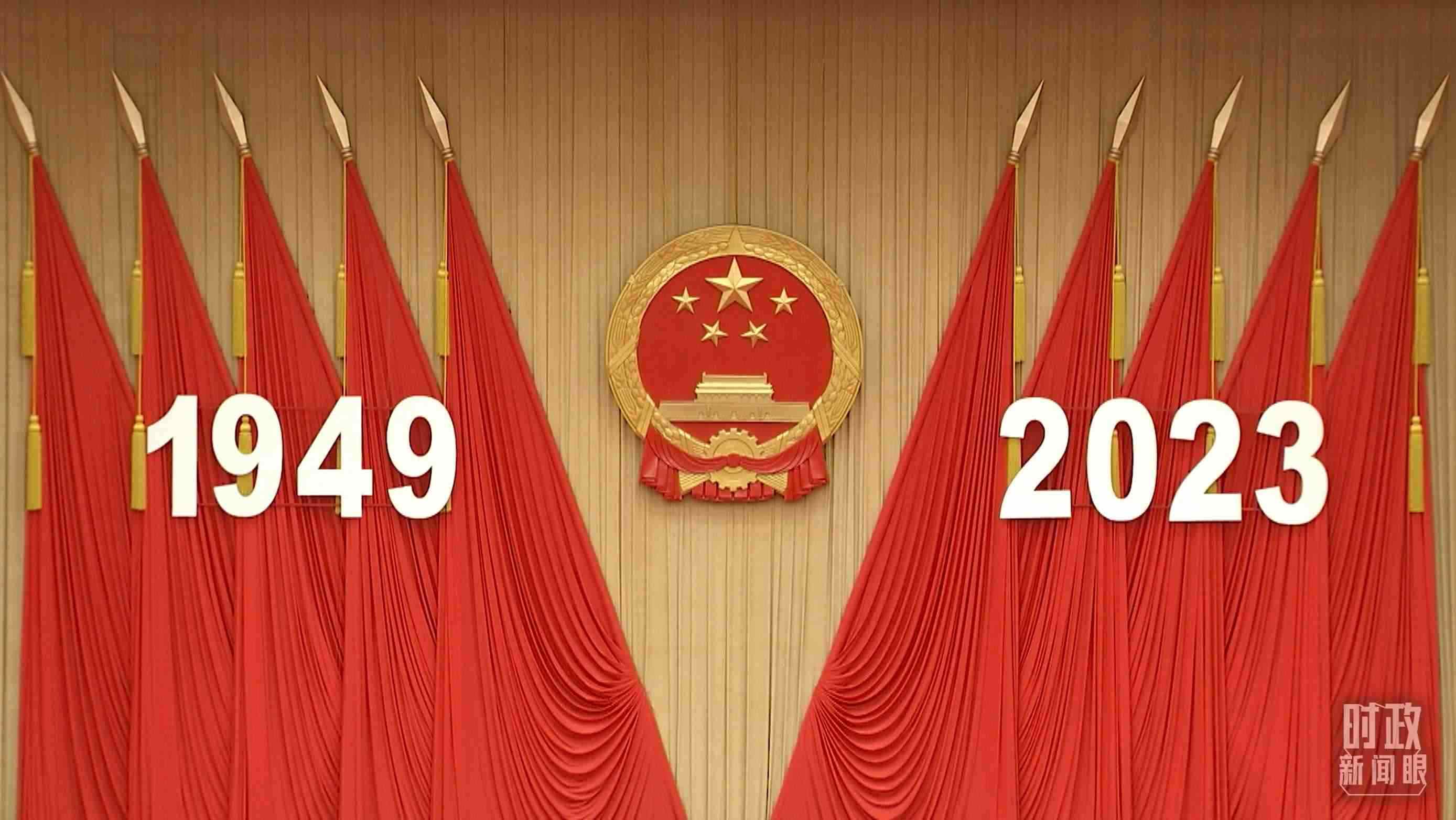 △人民大會(huì)堂宴會(huì)廳內(nèi)，主席臺(tái)上方高懸著莊嚴(yán)的國徽，“1949－2023”大字年號(hào)在鮮艷的紅旗映襯下格外醒目。