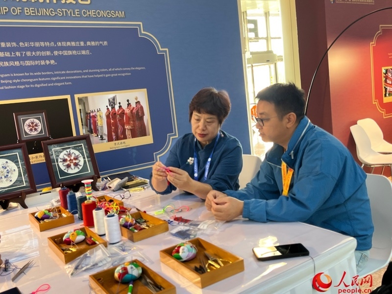 記者在新聞中心非遺傳承人展區(qū)進(jìn)行體驗(yàn)。人民網(wǎng)記者 杜燕飛攝