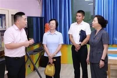 圖③：“小公民法律課堂”開講前，全國(guó)人大代表殷其龍（右二）、重慶市人大代表李自玲（左二）聽取楊家坪中學(xué)負(fù)責(zé)人關(guān)于未成年人思想教育工作情況的介紹。