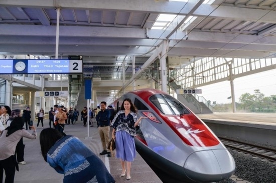  10月17日，在印度尼西亞萬隆德卡魯爾站，乘客在站臺上和雅萬高鐵高速動車組列車合影。新華社記者 徐欽 攝