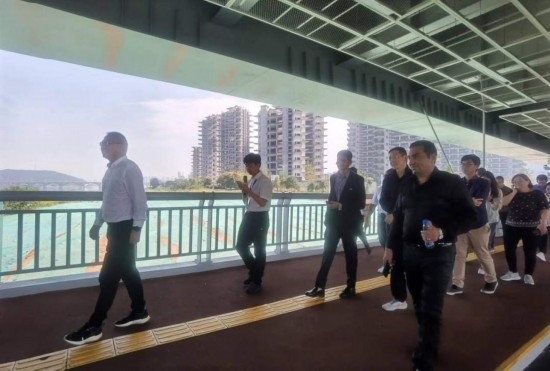 10月24日，2023“一帶一路”媒體合作論壇聯合采訪團團員走在清水塘大橋景觀通道上。本報記者 常雯宜攝