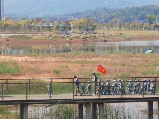 10月24日，秋游的幼兒園小朋友在老師帶領下走在清水塘公園里的木橋上。本報記者 常雯宜攝