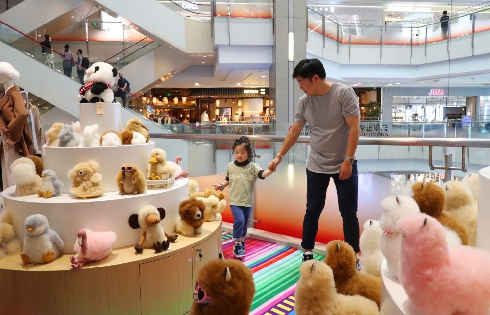 2023年11月2日，顧客在溫暖駝品牌專柜內(nèi)選購。連續(xù)六年參加進(jìn)博會的秘魯羊駝制品品牌溫暖駝在上海市中心商場開設(shè)了專柜。新華社記者 方喆 攝