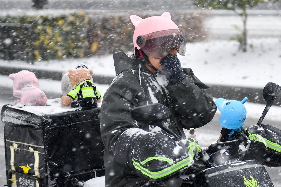 11月6日，在長(zhǎng)春市街頭，一名外賣員在雪中騎行。新華社記者 許暢 攝