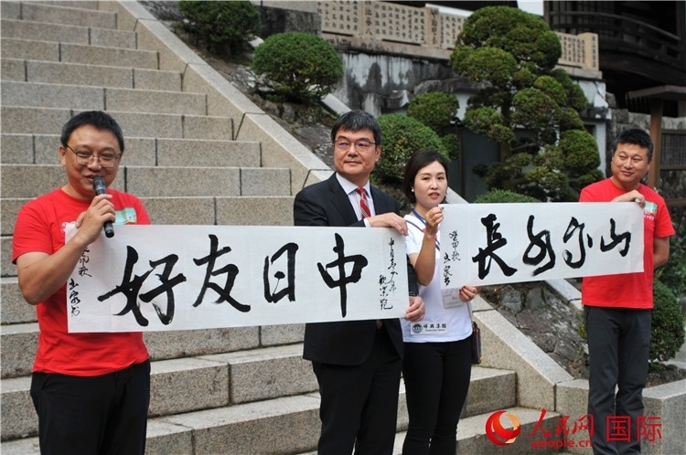 東京中國(guó)文化中心主任羅玉泉展示其為本次活動(dòng)書(shū)寫(xiě)的題詞“中日友好，山高水長(zhǎng)”。人民網(wǎng) 蔣曉辰攝