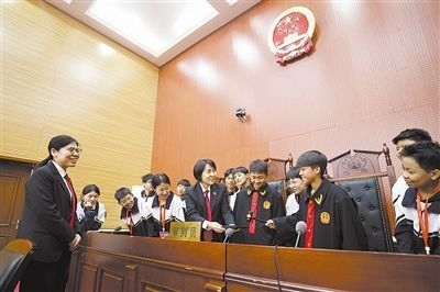 圖③：同學們穿法袍、敲法槌，爭做“小法官”。