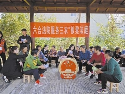  圖③：干警向附近農(nóng)戶解讀相關(guān)法律法規(guī)。