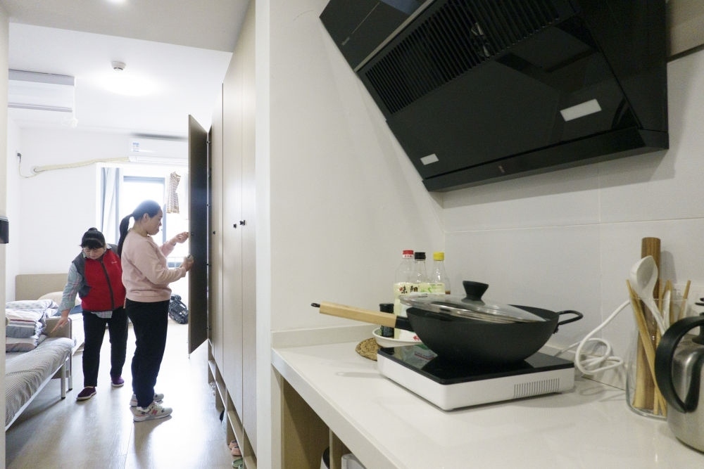 住戶在閔行區(qū)新時代城市建設者管理者之家收拾房間。